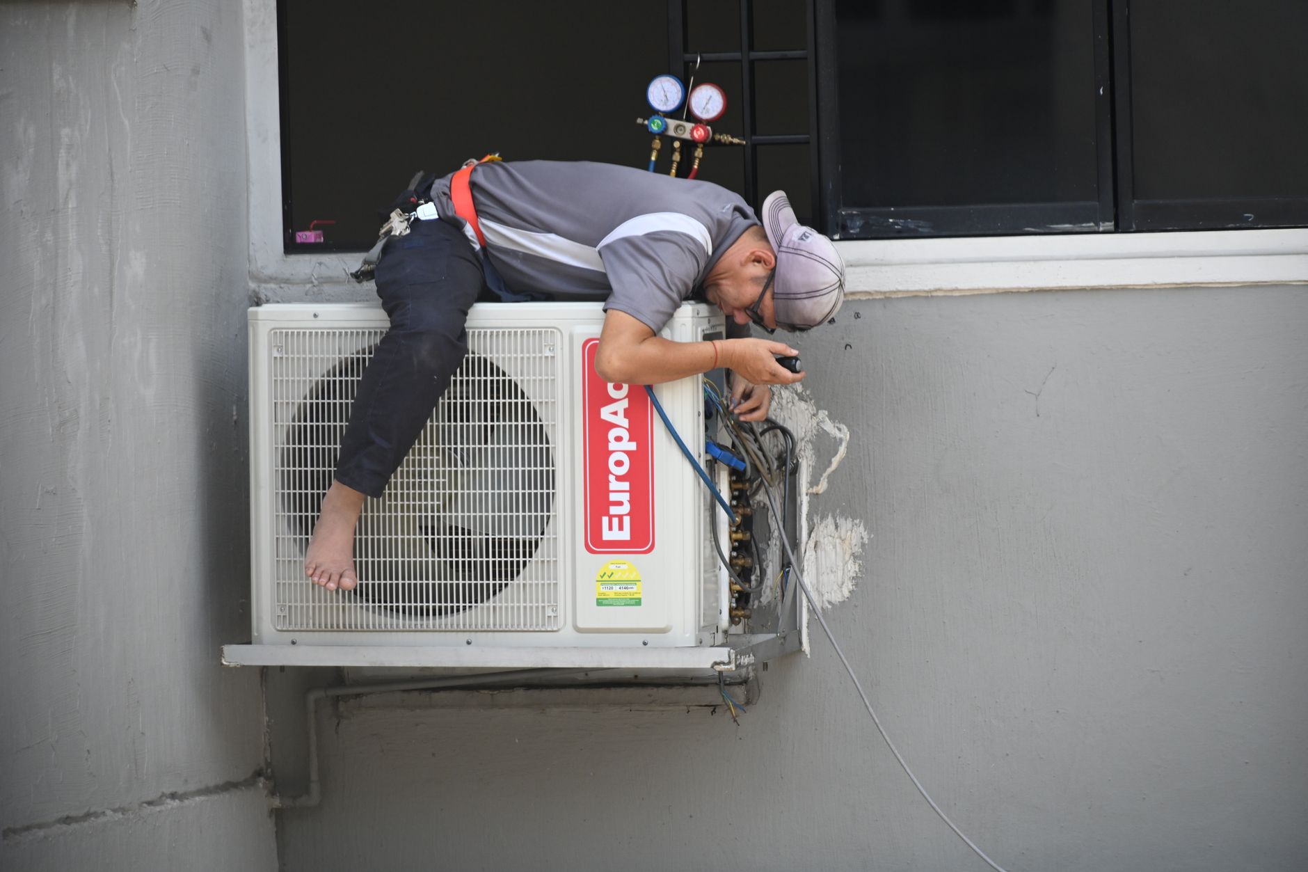 HVAC technician repairing an outdoor air conditioning unit