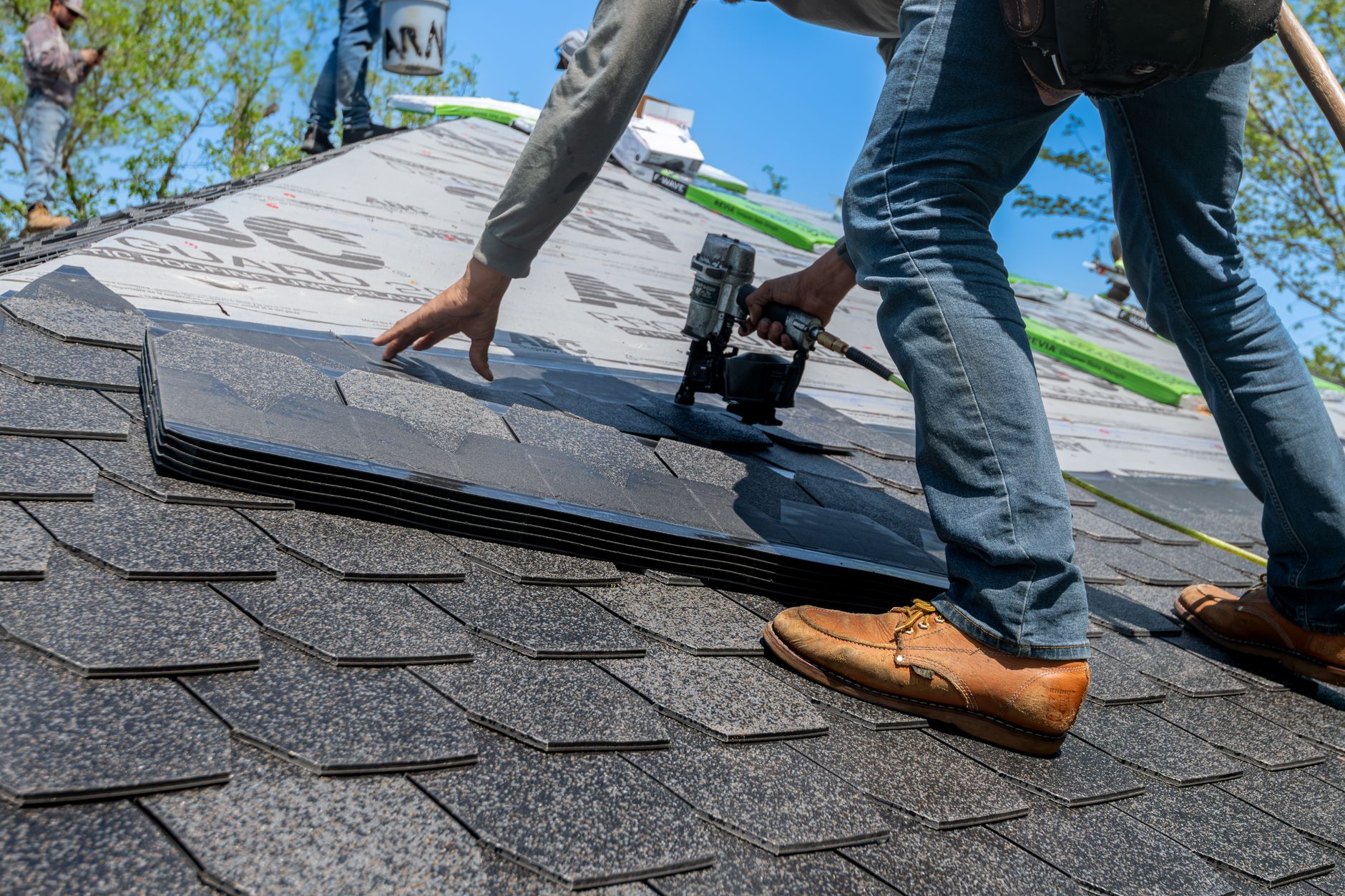 Roofer installing shingles on a roof