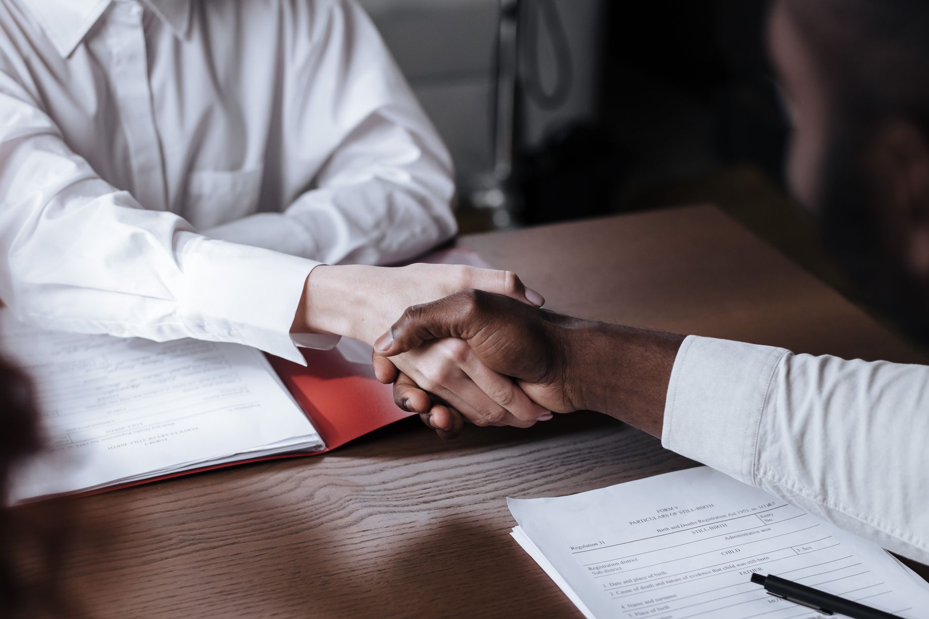 Business handshake over documents symbolizing agreement
