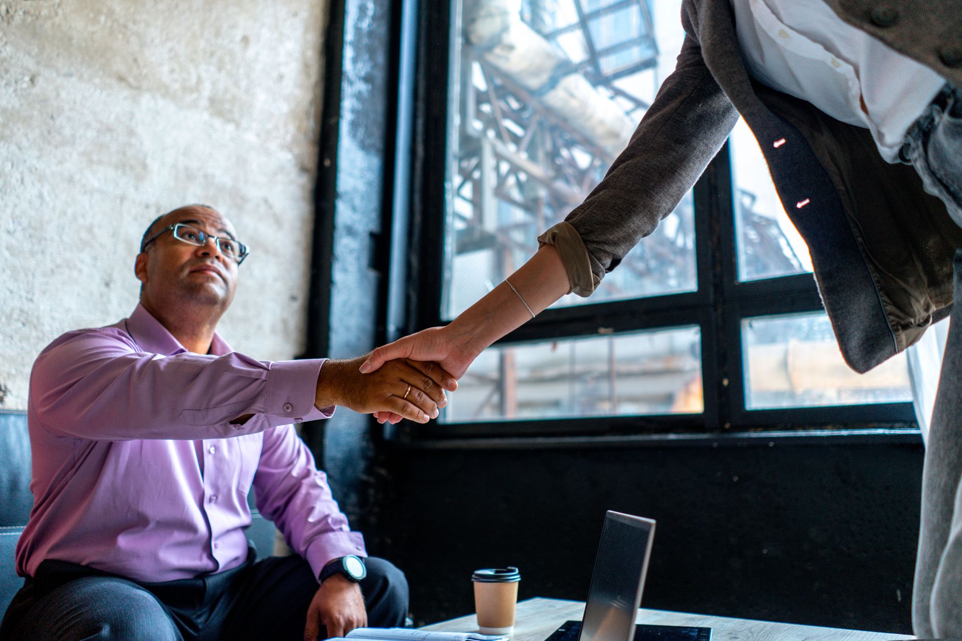 Professional handshake over a coffee table in an office