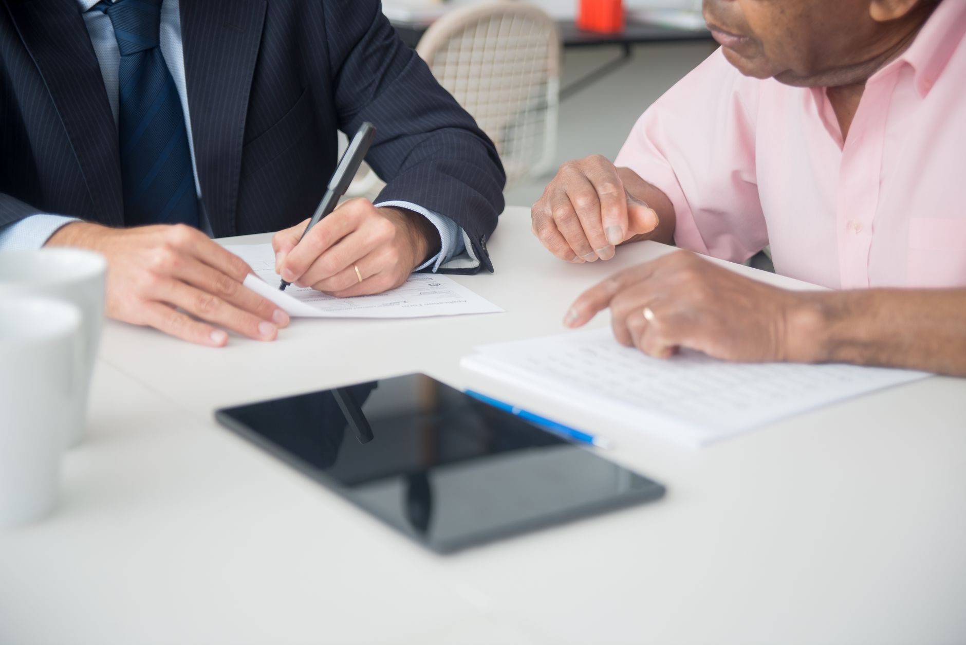 Two professionals discussing and signing documents in a meeting