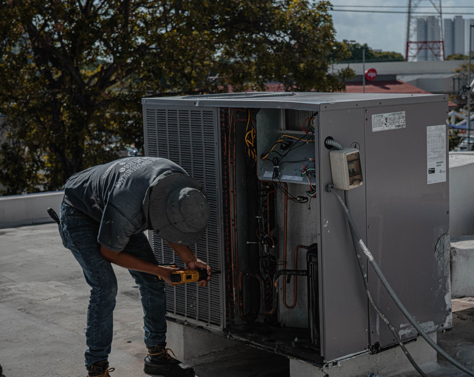 HVAC technician repairing a rooftop air-conditioning unit